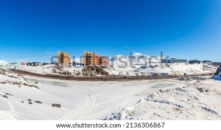 Greenlandic landscape with Inuit multistory houses of Nuuk city on the rocks with mountains in the background, Greenland