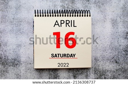 April 16. 16th day of month, calendar date. Stand for desktop calendar on beige wooden background. Concept of day of year, time planner, spring month.