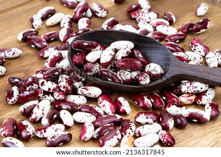 Red Anasazi Beans and wooden scoop. Spotted beans.Kidney beans.Haricot beans. Vegetarian food. Healthy protein food. Royalty-Free Stock Photo #2136317845