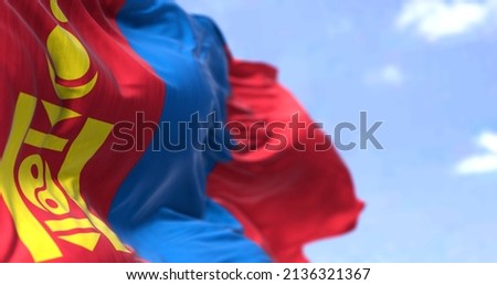 Detail of the national flag of Mongolia waving in the wind on a clear day. Mongolia is a landlocked country in East Asia. Selective focus. Royalty-Free Stock Photo #2136321367