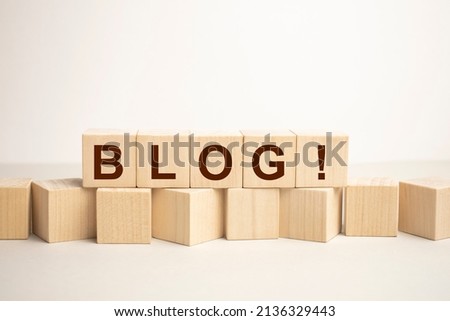 BLOG word written on wooden blocks on the edge of wooden table. Personal brand blogger concept, blogging as a profession, freelance online business concept.