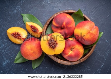 Fresh Yellow Peach fruit in wooden bowl on wooden background, Yellow Peach with slice in wooden basket. Royalty-Free Stock Photo #2136333285