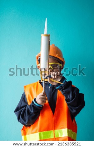Asian boy dressed as a craftsman and holding tools	