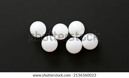 six white ping pong balls on black paper Royalty-Free Stock Photo #2136360023