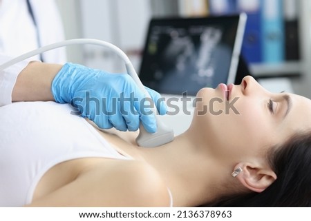 Ultrasound scanning diagnostic of woman thyroid gland in clinic, doctor runs ultrasound sensor Royalty-Free Stock Photo #2136378963