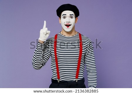 Insighted smart proactive fun young mime man with white face mask wears striped shirt beret holding index finger up with great new idea isolated on plain pastel light violet background studio portrait