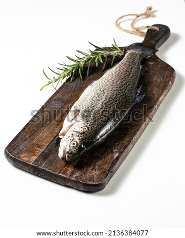 Raw trout with rosemary on a wooden background, isolated, healthy eating concept, fish. Stock photo