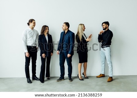 Many young businessmen and businesswomen in group meeting standing at conference hall in the office. Multicultural company organization unity and support.