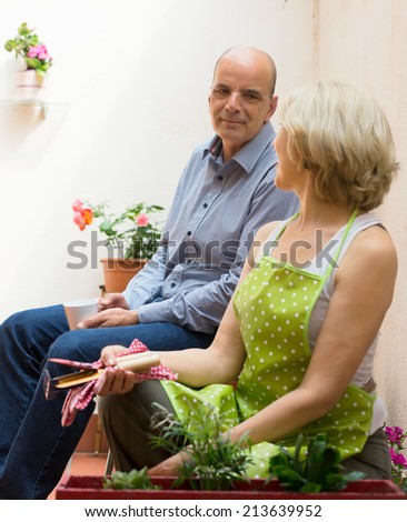 Smiling mature couple drinking coffee at terrace and talking