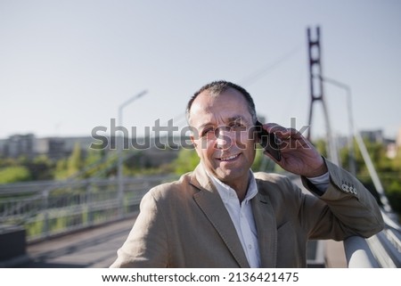 Businessman is talking on the phone outside