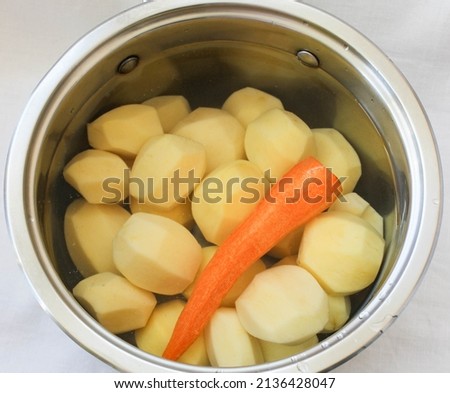 Potatoes and carrots in a pot of water.