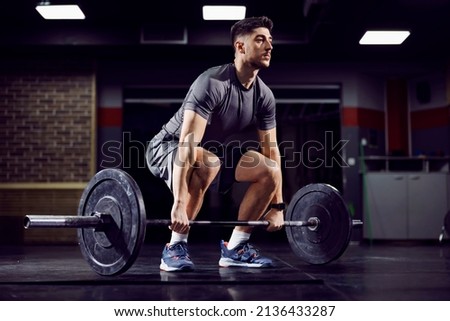 Fit sportsman doing deadlift at the gym and practicing functional training. Royalty-Free Stock Photo #2136433287