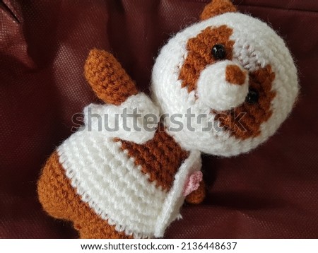 A cute crochet panda amigurumi in brown and white, beautiful hand made toy