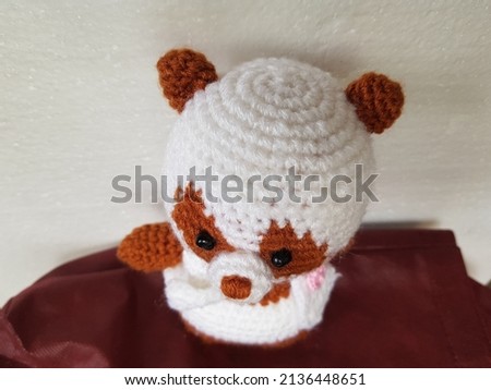 A cute crochet panda amigurumi in brown and white, beautiful hand made toy