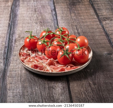 Plate with prosciutto parma and tomatoes, rustic table, italian breakfast, stock photo