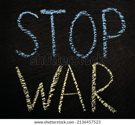 The inscription in chalk on a black rough background stop war. Stop the war in Ukraine written in blue-yellow chalk. Request to the world community to stop Russia's war against Ukraine