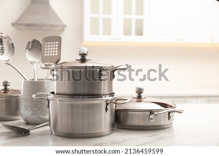 Set of stainless steel cookware and kitchen utensils on white table indoors, space for text Royalty-Free Stock Photo #2136459599