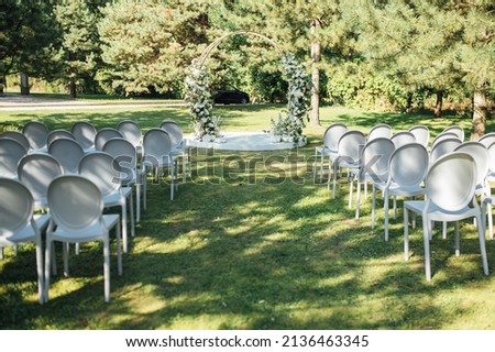 Very beautiful outside ceremony. classical wedding in forest. Metal arch with flowers.