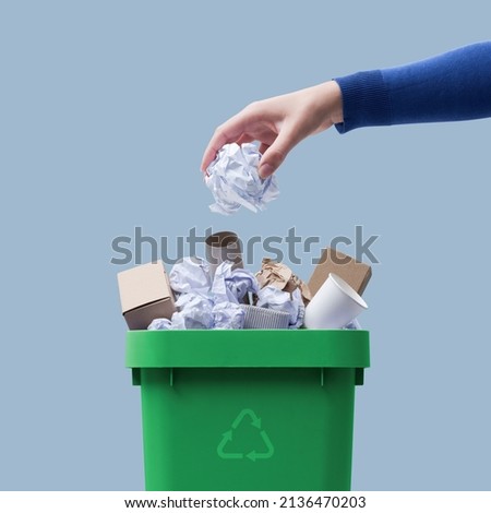 Woman putting paper in the waste bin, separate waste collection and recycling concept Royalty-Free Stock Photo #2136470203