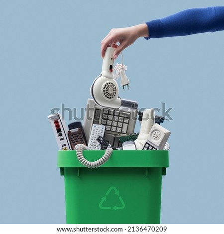 Woman putting an old broken appliance in the trash bin, e-waste and recycling concept Royalty-Free Stock Photo #2136470209