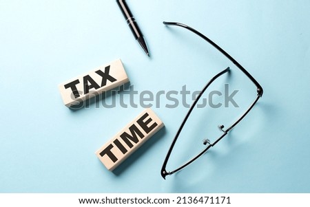 TAX TIME text on wooden block ,blue background