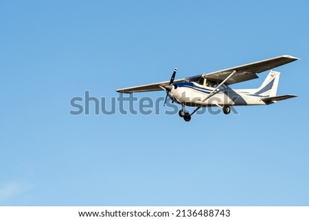 Small plane flying with sunset light in a clear sky before landing on Sabadell Airport. Royalty-Free Stock Photo #2136488743