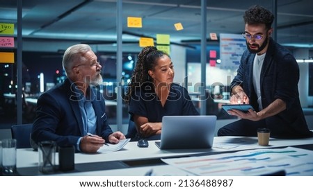 Office Conference Room Meeting: Diverse Team of Top Managers Talk, Brainstorm, Use Laptop Computer. Business Partners Discuss Financial Reports, Plan Investment Strategy and Managerial Operations. Royalty-Free Stock Photo #2136488987