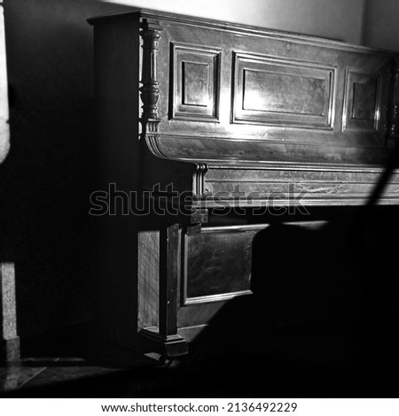 antique retro piano with wood carvings, hard light and shadows