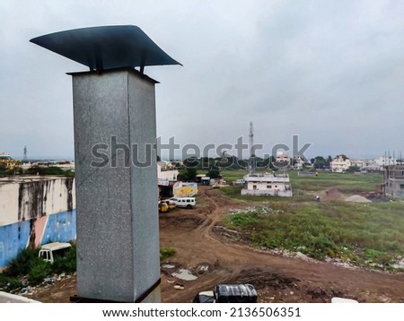 Stock photo of Metal chimney pipe on the rooftop of the house , residencial area on background. Picture captured at Gulbarga, Karnataka, India. focus on object.
