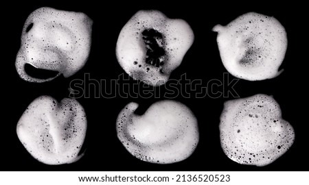 Top view, liquid white foam from soap or shampoo or shower gel. Abstract bubbles. isolated on a black background