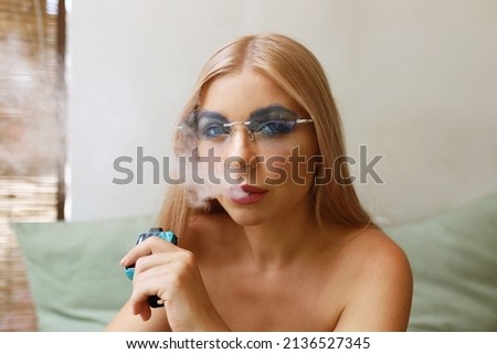 beautiful glamorous blonde girl smoke electronic cigarette