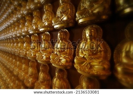 Wall of golden Buddha. 10,000 Golden Buddha in Chinese temple.
