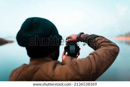Photographer taking photographs with digital camera in a mountains, Photography day Concept Image