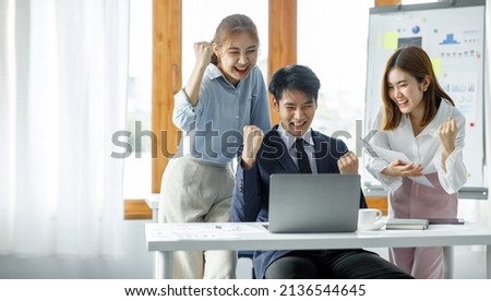 Group of Young Asian business team creative businesspeople coworker in office Happy to be successful partnership teamwork celebrating achievement and success concept. Royalty-Free Stock Photo #2136544645