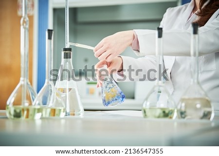 Chemical laboratory. Hand with flask during titrimetric analysis or titration Royalty-Free Stock Photo #2136547355