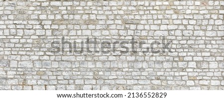 Rustic rough garden wall made of sandstone blocks.