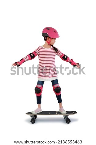 Asian little girl child skating on skateboard isolated over white background. Kid riding on skateboard. Image with Clipping path Royalty-Free Stock Photo #2136553463