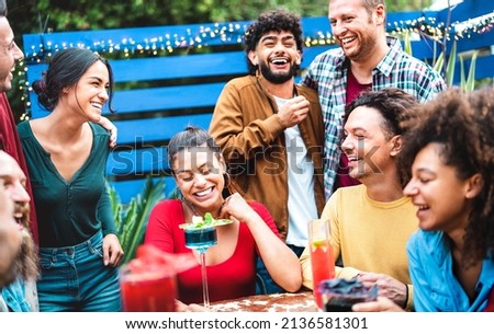 Millennial trendy people having fun moment at fancy cocktail bar patio - Beverage life style concept with friends laughing together on happy hour at sidewalk restaurant garden - Bright vivid filter Royalty-Free Stock Photo #2136581301