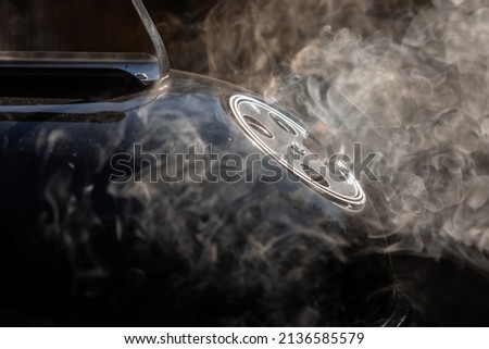 Smoke coming out from ventilation opening of a smoker grill. Round ventilation opening in open position to allow exit of smoke fumes. Royalty-Free Stock Photo #2136585579
