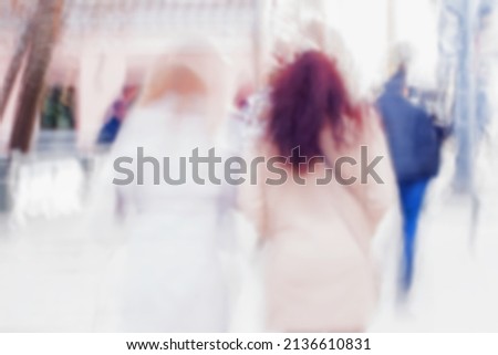 Abstract background of girls hurrying down the city street back to us. Intentional motion blur. Concept of seasons, shopping, walking, lifestyle, modern city.