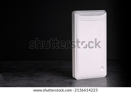 White Power Bank for starting the car engine with a flashlight on a dark background. Selective focus