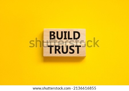 Build trust symbol. Concept words Build trust on wooden blocks on a beautiful yellow table yellow background. Business and build trust concept, copy space. Royalty-Free Stock Photo #2136616855