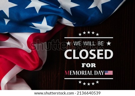 Memorial Day Background Design. American flag on a background of wooden teable with a message. We will be Closed for Memorial Day.