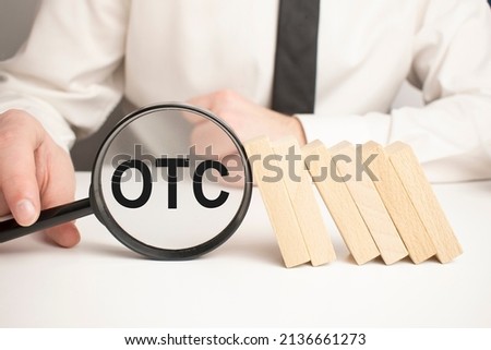 Top view of magnifying glass and alphabet letters with text OTC stands for Over-the-counter. Business concept. Royalty-Free Stock Photo #2136661273