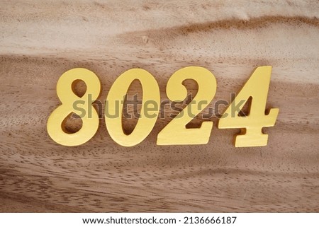 Wooden  numerals 8024 painted in gold on a dark brown and white patterned plank background.