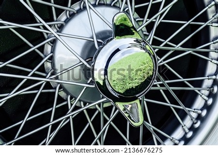 Antique chrome spoke wheel with white-faced rubber and center nut Royalty-Free Stock Photo #2136676275