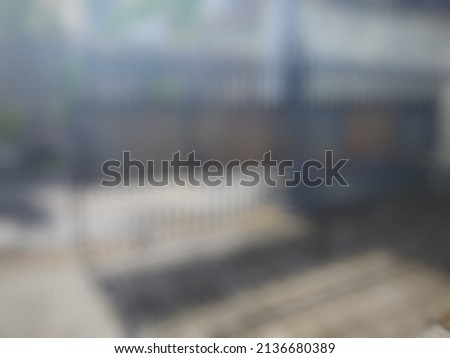 Defocused abstract background of a rolling iron front gate in a yard