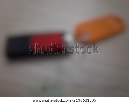 Defocused abstract background of a small flash disk and its yellow sign on the table