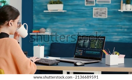 Content creator creating film montage with video editing software on laptop, working on online course assignment from home. Media designer developing movie making production on app.