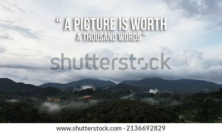 " A picture is worth a thounds word " english proverbs on background of mountain hill with cloud